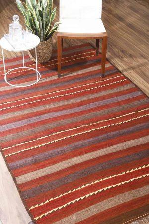 Deep red and brown linear patterns on a Balouchi kilim rug by Carpet Cellar