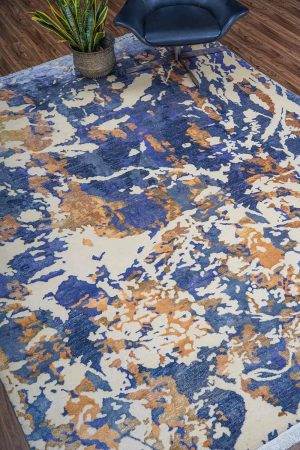 Off-white and beige patches of colour on a blue modern carpet by Carpet Cellar